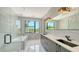 Modern bathroom with double vanity, soaking tub, and walk-in shower with glass door at 1607 Flower Dr, Sarasota, FL 34239