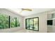 Bright, airy bedroom with neutral walls, tile floors, ceiling fan, and view of exterior balcony at 1607 Flower Dr, Sarasota, FL 34239