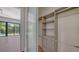 Spacious closet with custom shelving, drawers, rod system and beautiful floors, with a bedroom beyond at 1607 Flower Dr, Sarasota, FL 34239