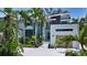 Stunning contemporary home featuring a clean white facade, palm trees, and lush landscaping at 1607 Flower Dr, Sarasota, FL 34239