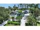 Aerial view of modern home with lush tropical landscaping and a spacious front yard and two car garage at 1607 Flower Dr, Sarasota, FL 34239