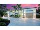 Stunning modern home showcasing lush landscaping, palm trees, and a spacious driveway at 1607 Flower Dr, Sarasota, FL 34239
