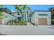 Stunning contemporary home featuring a clean white facade, palm trees, and lush landscaping at 1607 Flower Dr, Sarasota, FL 34239
