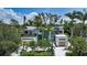 Aerial view of modern home with lush tropical landscaping and a spacious front yard and two car garage at 1607 Flower Dr, Sarasota, FL 34239