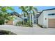 Stunning contemporary home featuring a clean white facade, palm trees, and lush landscaping at 1607 Flower Dr, Sarasota, FL 34239