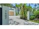 Modern home with a wood garage door, decorative garden, and welcoming driveway at 1607 Flower Dr, Sarasota, FL 34239