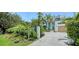 Well landscaped exterior with a colorful garden design and palm trees lining the driveway at 1607 Flower Dr, Sarasota, FL 34239