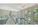Modern hallway with glass railings, stylish light fixtures, and bright natural light from large windows at 1607 Flower Dr, Sarasota, FL 34239