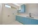Bright laundry room with blue cabinets, white countertops and a sleek modern design at 1607 Flower Dr, Sarasota, FL 34239