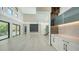 Open concept living room with bright tile floors, high ceilings, access to balcony, fireplace and adjacent kitchen at 1607 Flower Dr, Sarasota, FL 34239