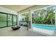 Covered outdoor patio featuring a fire pit and a view of the sparkling swimming pool surrounded by lush landscaping at 1607 Flower Dr, Sarasota, FL 34239