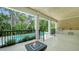 Covered patio area with an outdoor kitchen, fire pit, and pool view, perfect for entertaining at 1607 Flower Dr, Sarasota, FL 34239