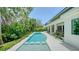 A stunning backyard with a luxurious pool surrounded by tropical greenery and lush landscaping at 1607 Flower Dr, Sarasota, FL 34239