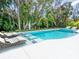 Inviting backyard pool surrounded by lush greenery and lounge chairs at 1607 Flower Dr, Sarasota, FL 34239
