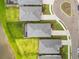 Overhead view of three homes with well manicured lawns, black fencing, and grey tile roofing near a tranquil pond at 18317 Gulf Ranch Pl, Bradenton, FL 34211