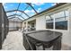 Outdoor patio featuring a hot tub, seating and umbrella, and a screened in enclosure at 18317 Gulf Ranch Pl, Bradenton, FL 34211