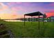 Beautiful backyard with lush green lawn, a pergola and lake view, perfect for outdoor relaxation and entertainment at 18317 Gulf Ranch Pl, Bradenton, FL 34211