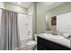 Clean bathroom featuring a shower-tub combo, light green paint, and a modern vanity with neutral countertop at 18317 Gulf Ranch Pl, Bradenton, FL 34211