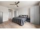 This bedroom features wood floors, a ceiling fan, a bed with gray and white bedding, and a gray wardrobe closet at 18317 Gulf Ranch Pl, Bradenton, FL 34211