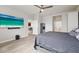 This bedroom features wood floors, a ceiling fan, a bed with gray and white bedding, and a mounted flat screen television at 18317 Gulf Ranch Pl, Bradenton, FL 34211