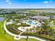 Aerial view of the resort style community pool, splashpad and lounging area with lush landscaping at 18317 Gulf Ranch Pl, Bradenton, FL 34211