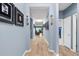 Hallway featuring light wood floors, gallery wall, and views into the living room at 18317 Gulf Ranch Pl, Bradenton, FL 34211