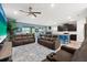 Spacious living area featuring dual reclining sofas, adjacent to a kitchen area with stainless steel appliances at 18317 Gulf Ranch Pl, Bradenton, FL 34211