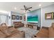 Open concept living room features comfortable leather couches, a flat screen television, and electric fireplace at 18317 Gulf Ranch Pl, Bradenton, FL 34211