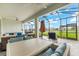 Spacious screened-in patio with ample seating and a dining table overlooking the backyard and hot tub at 18317 Gulf Ranch Pl, Bradenton, FL 34211