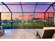 Stunning sunset view from the covered patio with spa, inviting relaxation and entertainment outdoors in the evening at 18317 Gulf Ranch Pl, Bradenton, FL 34211