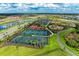 A vibrant aerial view of multiple tennis courts and recreational facilities in a Primary-planned community at 18317 Gulf Ranch Pl, Bradenton, FL 34211