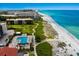 Stunning aerial view of beachfront community, pool, and lush landscaping at 2045 Gulf Of Mexico Dr # M1-505, Longboat Key, FL 34228