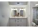 Bright bathroom with a double sink, modern mirrors and gold-colored hardware at 2045 Gulf Of Mexico Dr # M1-505, Longboat Key, FL 34228