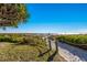 Sandy path leads to the beach, surrounded by lush greenery, and promises serene coastal living at 2045 Gulf Of Mexico Dr # M1-505, Longboat Key, FL 34228