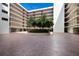 Beautiful courtyard with lush trees, colorful flowers, and brick-paved driveway at this modern condo complex at 2045 Gulf Of Mexico Dr # M1-505, Longboat Key, FL 34228