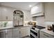 Kitchen area with white cabinetry, stainless appliances and hardwood style flooring at 2045 Gulf Of Mexico Dr # M1-505, Longboat Key, FL 34228