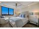 Bright main bedroom with a comfy chair, a large window and a ceiling fan at 2045 Gulf Of Mexico Dr # M1-505, Longboat Key, FL 34228