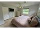 Comfortable bedroom featuring a mounted television, neutral walls, and light stone flooring at 2159 Constitution Blvd, Sarasota, FL 34231