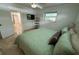 Bedroom with tile flooring, small tv, green comforter, and plenty of natural light at 2159 Constitution Blvd, Sarasota, FL 34231