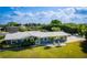 Beautiful blue house with a metal roof, lush green lawn, and inviting chairs on the front porch at 2159 Constitution Blvd, Sarasota, FL 34231