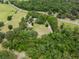 Aerial view capturing home surrounded by dense trees and open yard space at 22063 Lake Lindsey Rd, Brooksville, FL 34601