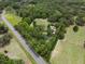 Aerial view highlighting the home and its expansive, tree-filled surroundings at 22063 Lake Lindsey Rd, Brooksville, FL 34601