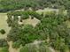 Home with surrounding trees and open land, seen from above in an aerial view at 22063 Lake Lindsey Rd, Brooksville, FL 34601