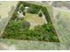 Aerial view showcasing property lines, home, and surrounding lush landscape at 22063 Lake Lindsey Rd, Brooksville, FL 34601