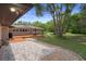 Backyard featuring a wooden deck, stone walkway, lush lawn and mature trees at 22063 Lake Lindsey Rd, Brooksville, FL 34601