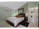 Comfortable bedroom with ensuite bathroom featuring soft carpet, neutral paint, and modern lighting at 22063 Lake Lindsey Rd, Brooksville, FL 34601