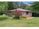 Charming single-story home with a wood porch, manicured landscaping and beautiful flowering tree at 22063 Lake Lindsey Rd, Brooksville, FL 34601