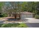 Charming ranch-style home with mature trees, a two-car garage, and a cozy front deck at 22063 Lake Lindsey Rd, Brooksville, FL 34601