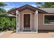 Home's inviting front entrance features a brown door with glass detail, and stone porch at 22063 Lake Lindsey Rd, Brooksville, FL 34601