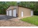 Exterior garage featuring three bays and a side door, showcasing ample storage and parking space at 22063 Lake Lindsey Rd, Brooksville, FL 34601